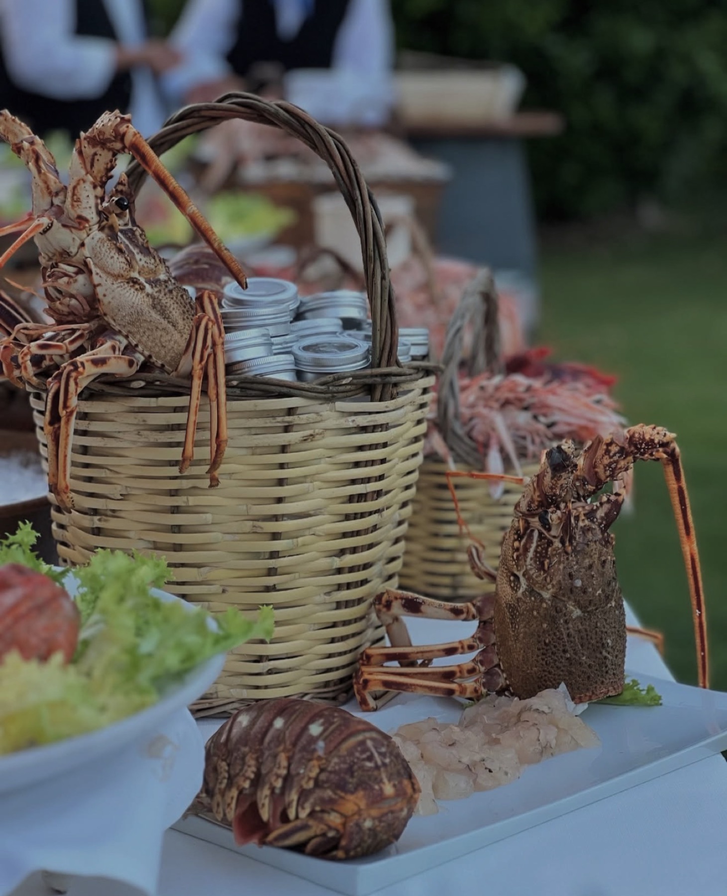 Cesto di vimini con aragoste fresche e conserve al banco eventi di Punto Blu