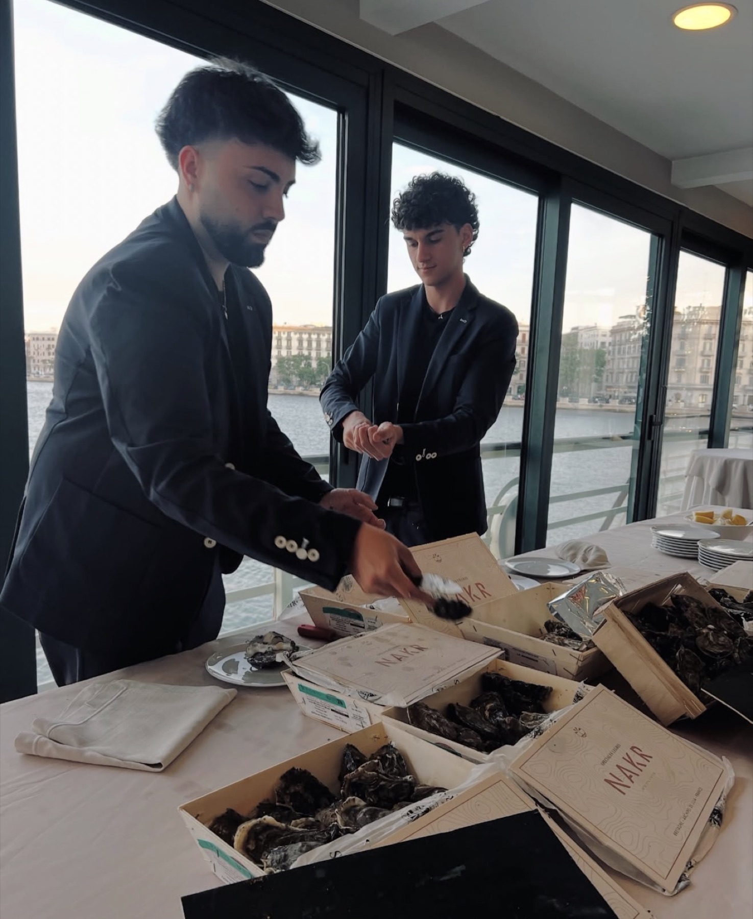 Preparazione delle ostriche in sala con vista sul mare di Bari